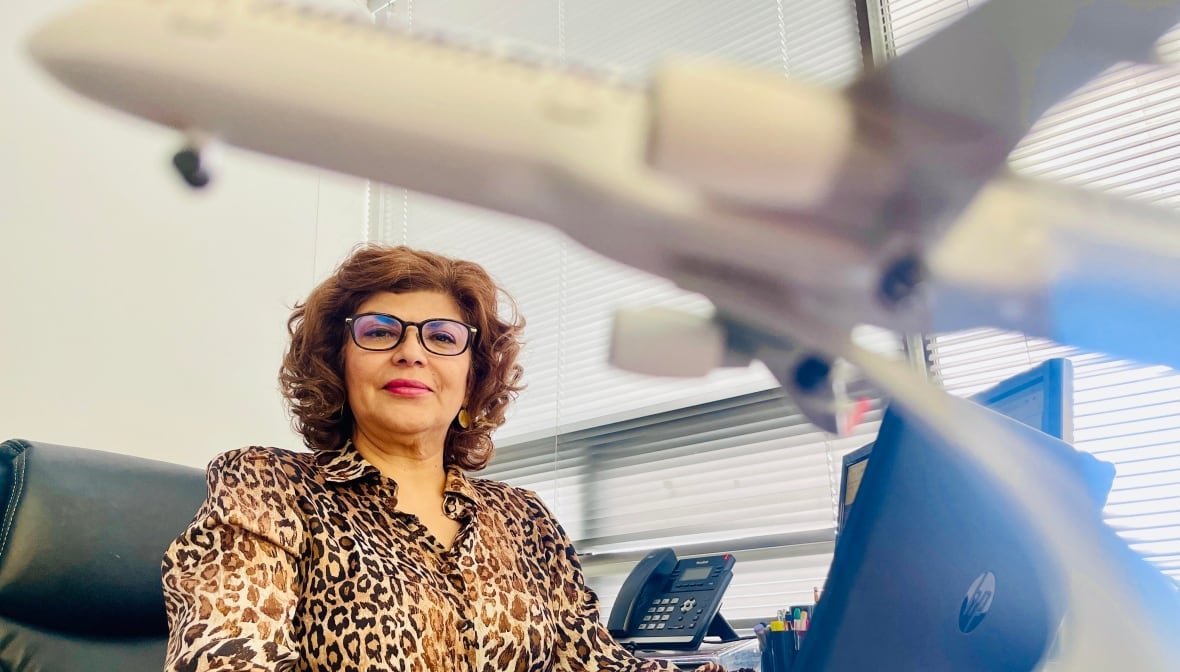 azin-mohager-manager-of-atlas-travel-in-toronto Azin Mohager sitting at a desk at Atlas Travel.