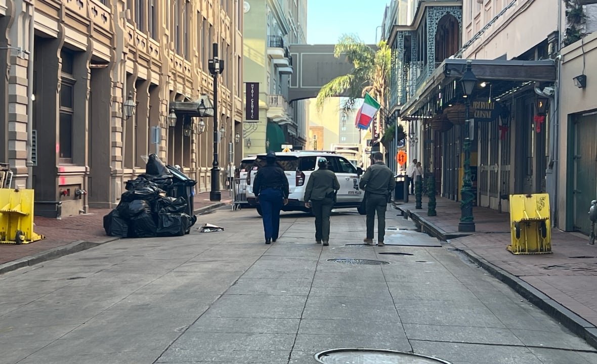 Three police officers can be seen in the distance walking away from the camera down a city street.