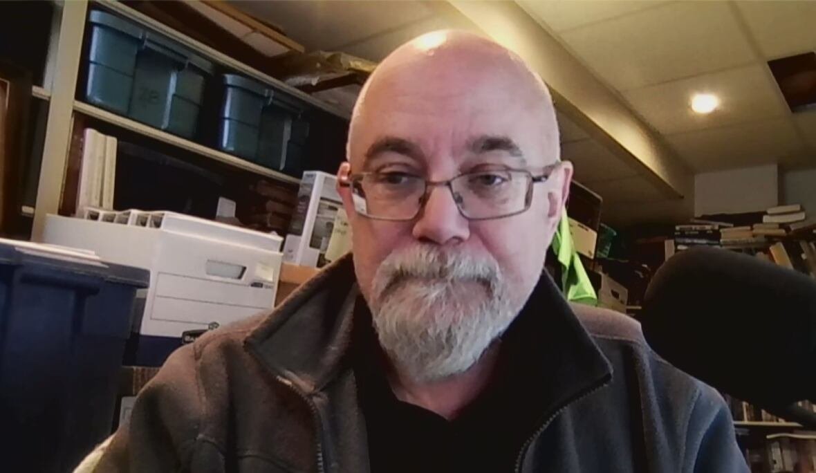 A man in a dark archival room.
