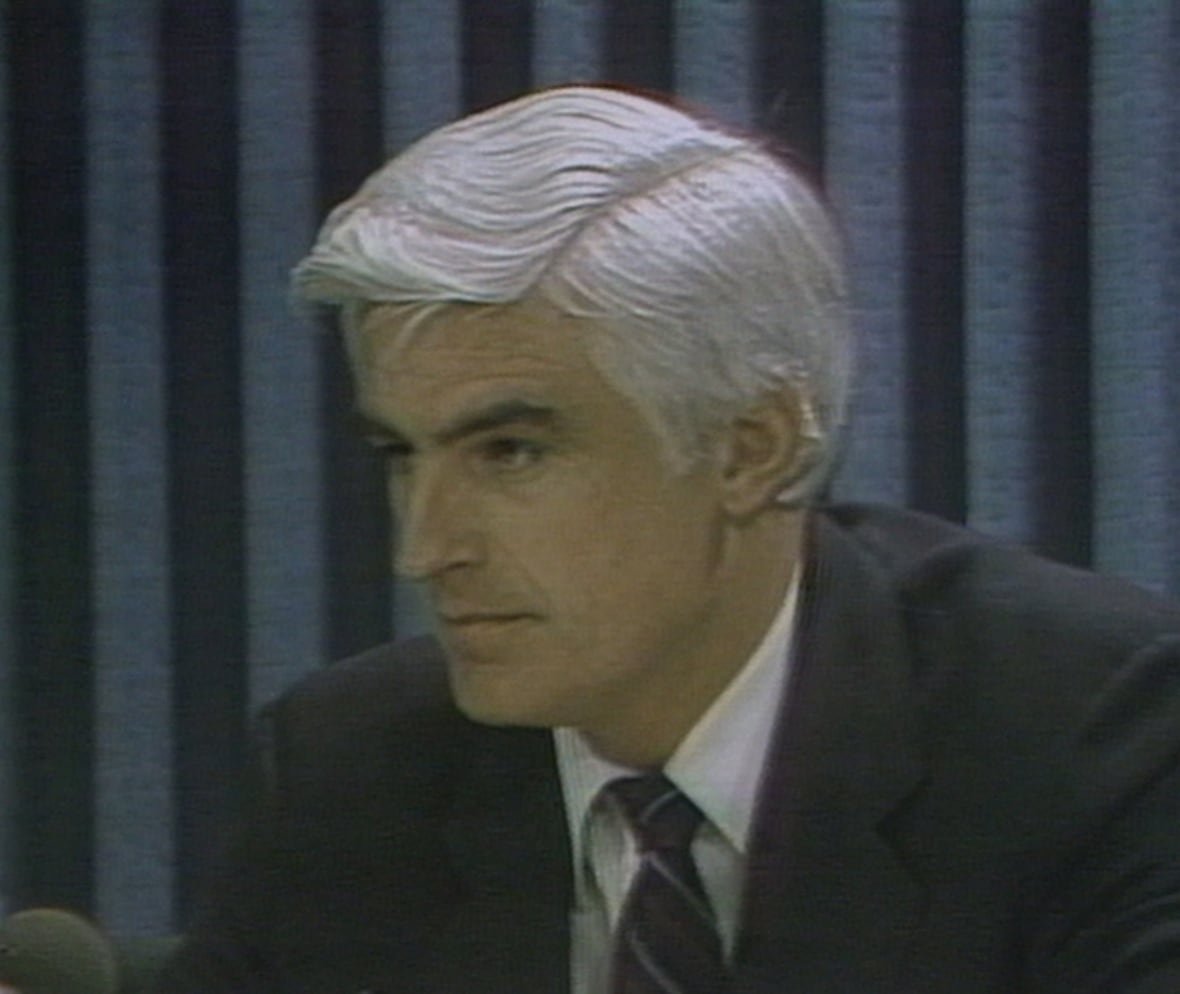 ed-lumley-speaks-to-reporters-in-august-1982 Man with white hair