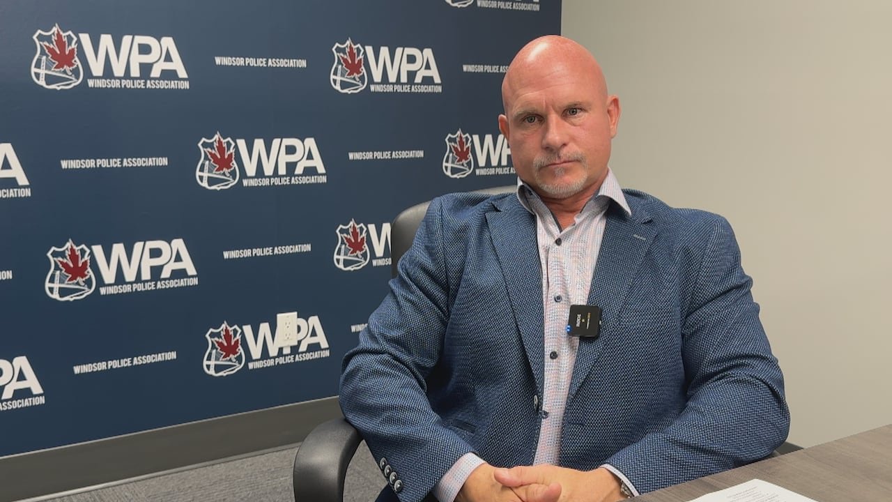 Kent Rice seated in front of a wall displaying the Windsor Police Association's logo