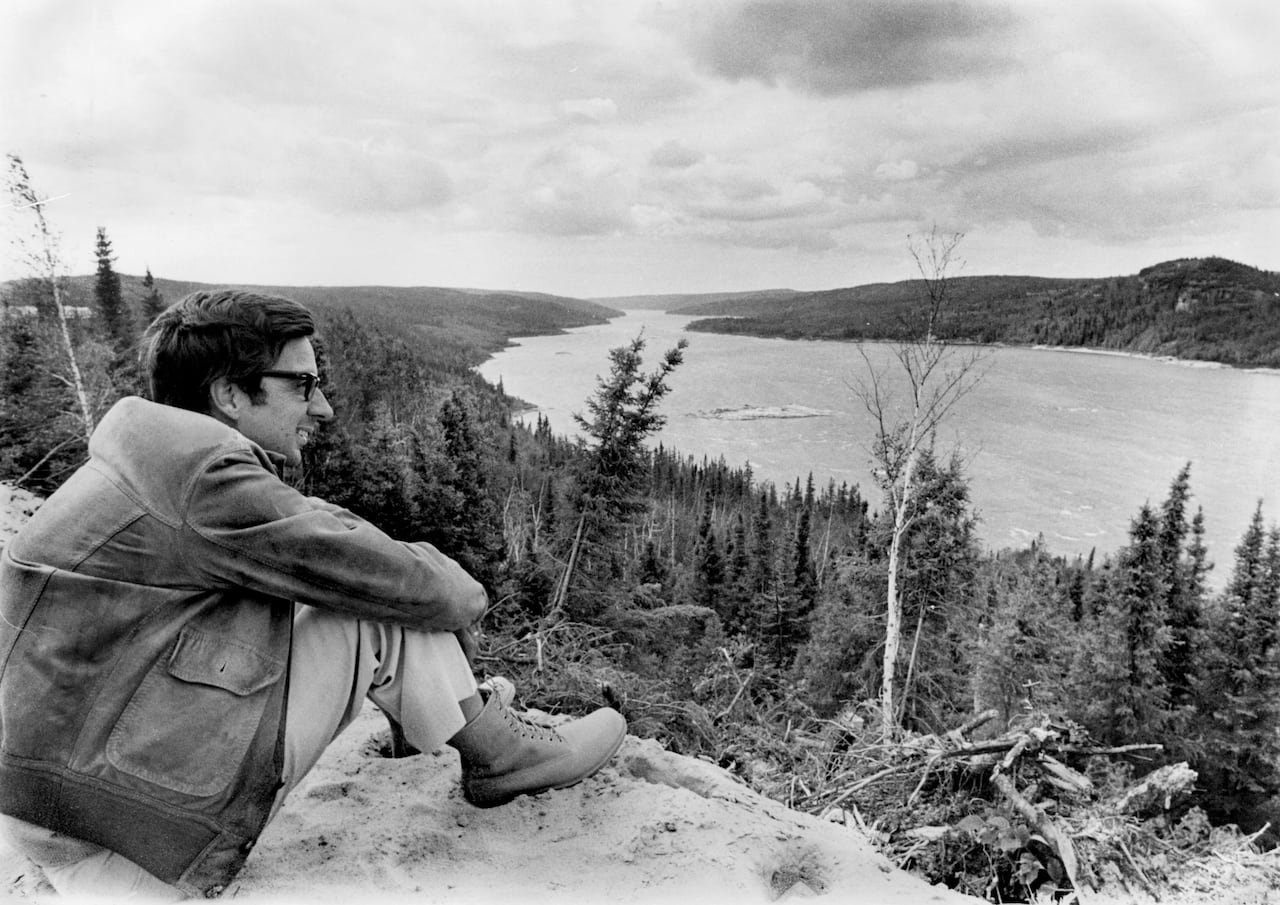 A man overlooking a river in a black and white photograph