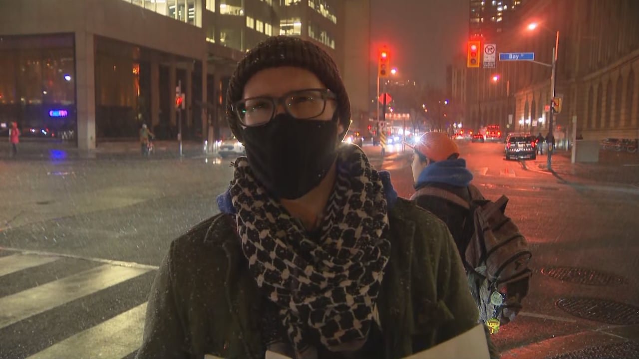default-384 A protester in a winter hat and face mask stands in downtown Toronto following a protest regarding the Munk Debates.