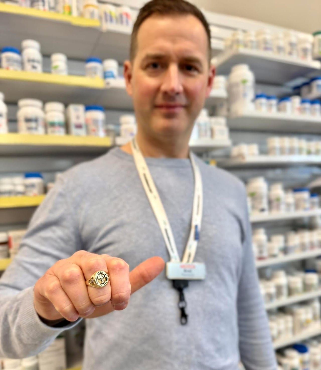 default-13 A man displaying a golden ring on his finger in a pharmacy.