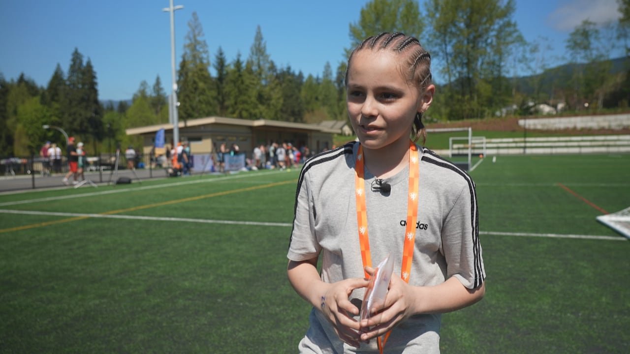 A child with braids smiling at the camera.