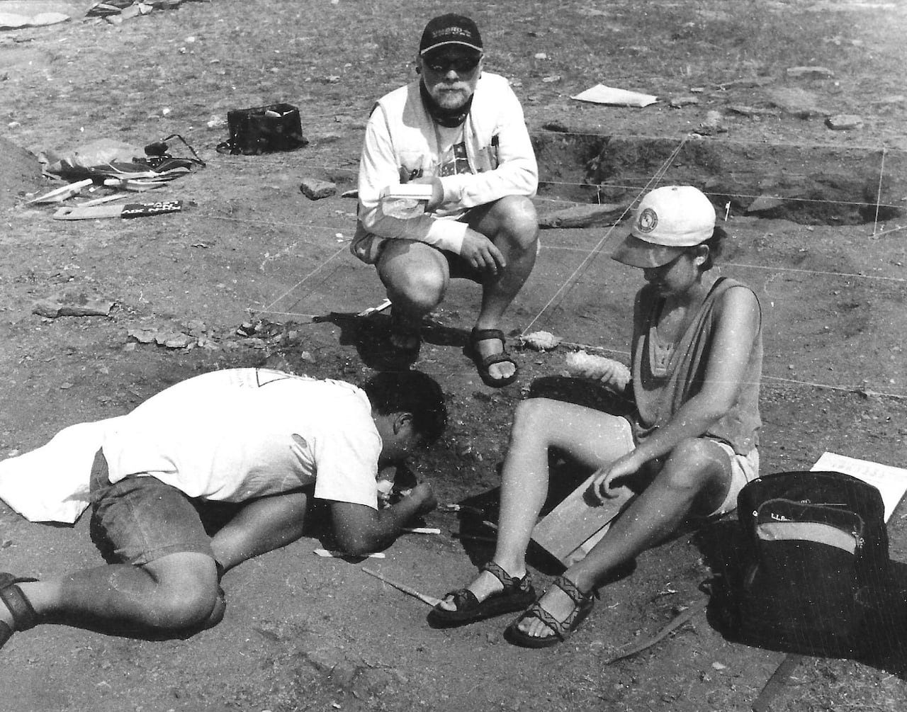 default-43 Old photo of two individuals in baseball caps observing an archaeological dig in Russia