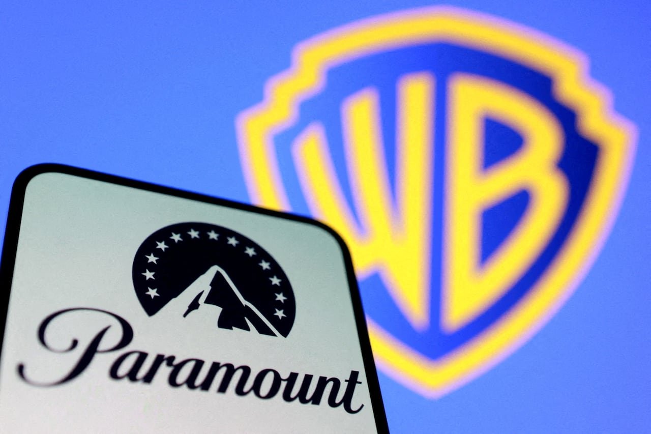 default-28 An illustration shows the Paramount mountain logo in black and white to the left, with the yellow Warner Bros logo over blue seen in the background.