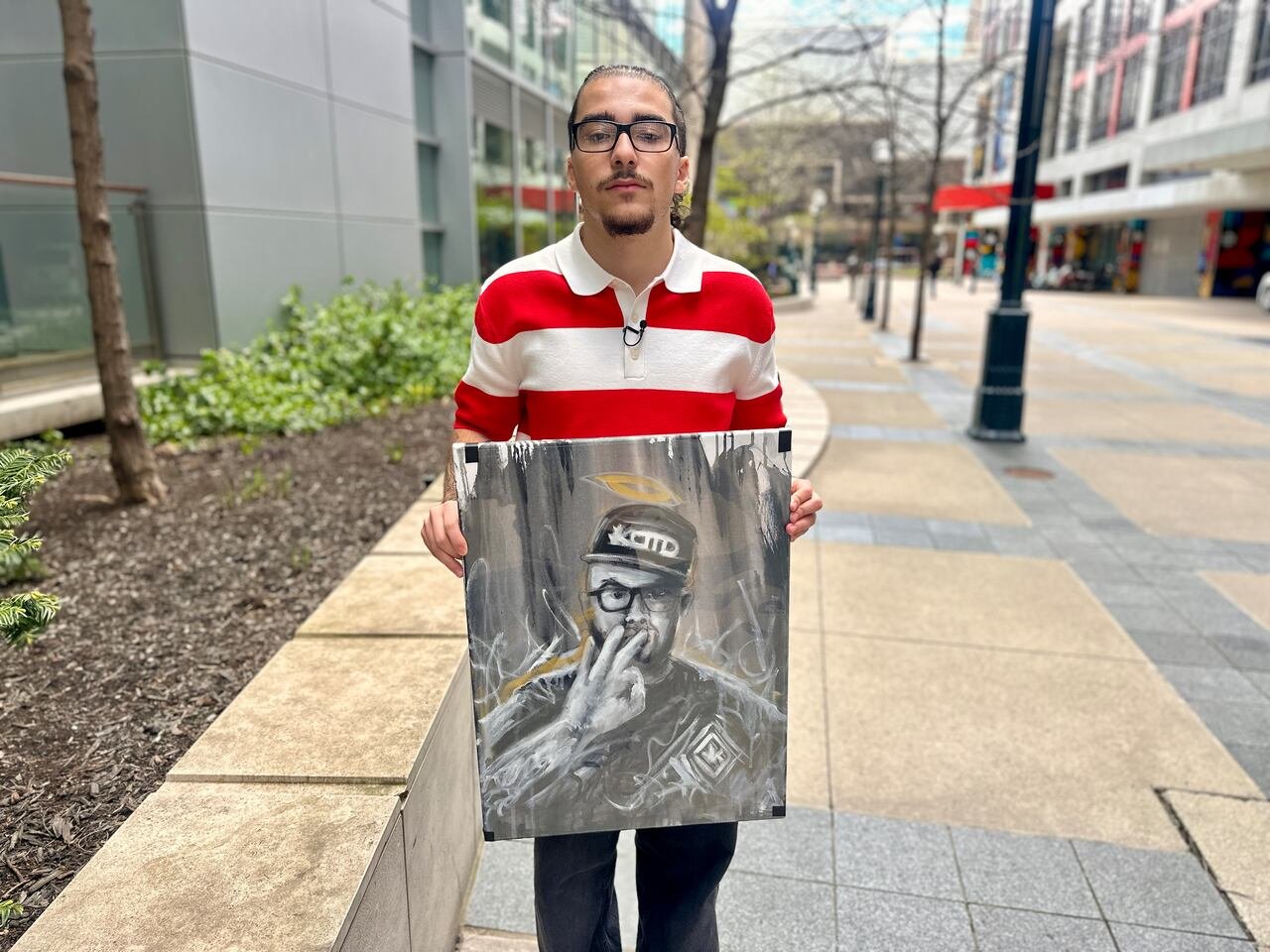 Carlito Parra, 20, holds a painting of his father Nickolas who died from colon cancer after more than 15 years of symptoms. His father advocated for the screening age to be lowered in his final months.